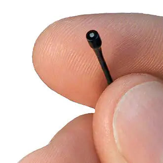 Black cylindrical camera lens held between fingers.