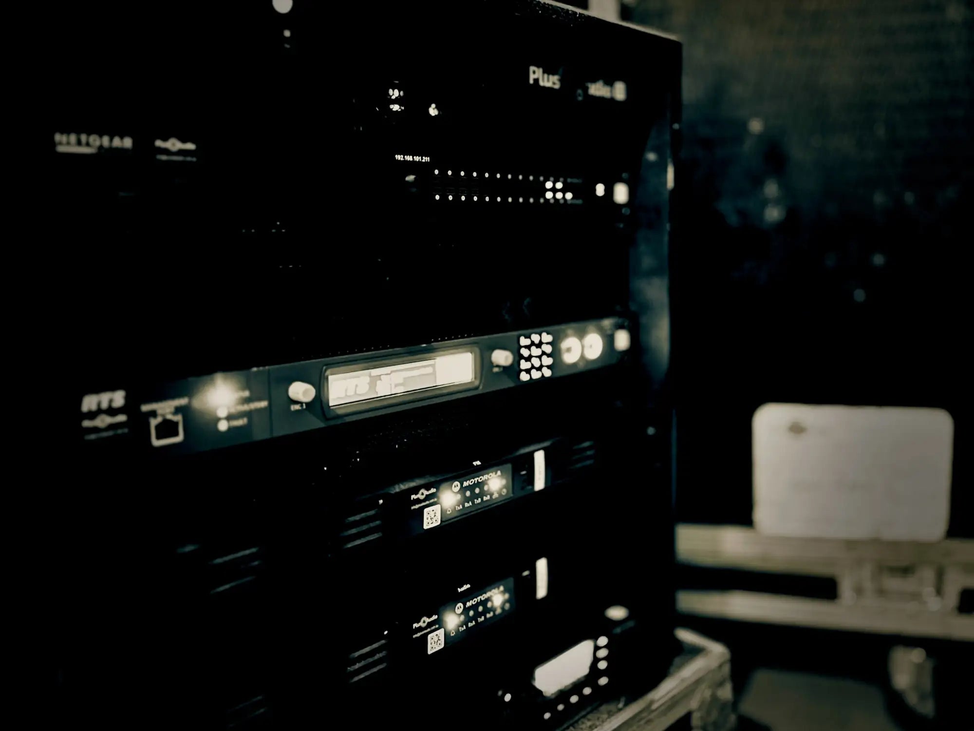 Black netgear plus audio equipment rack with illuminated controls and indicator lights.