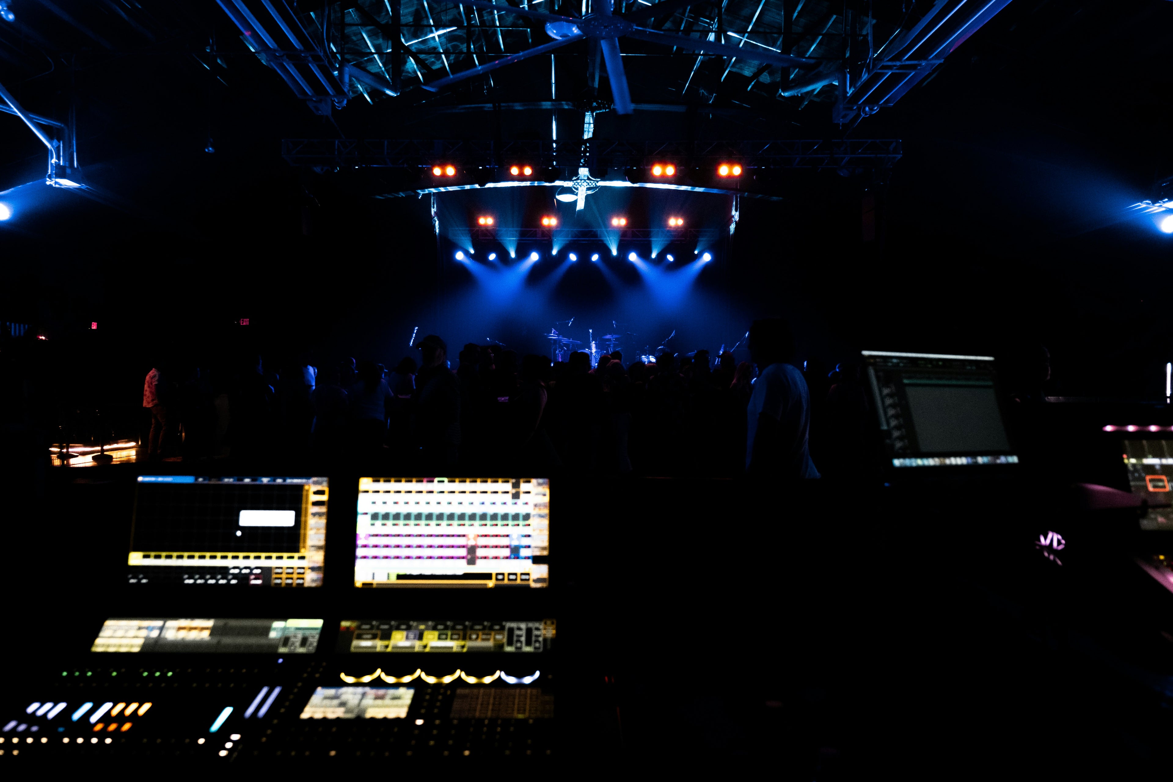 Control room with multiple screens and equipment in a dark setting