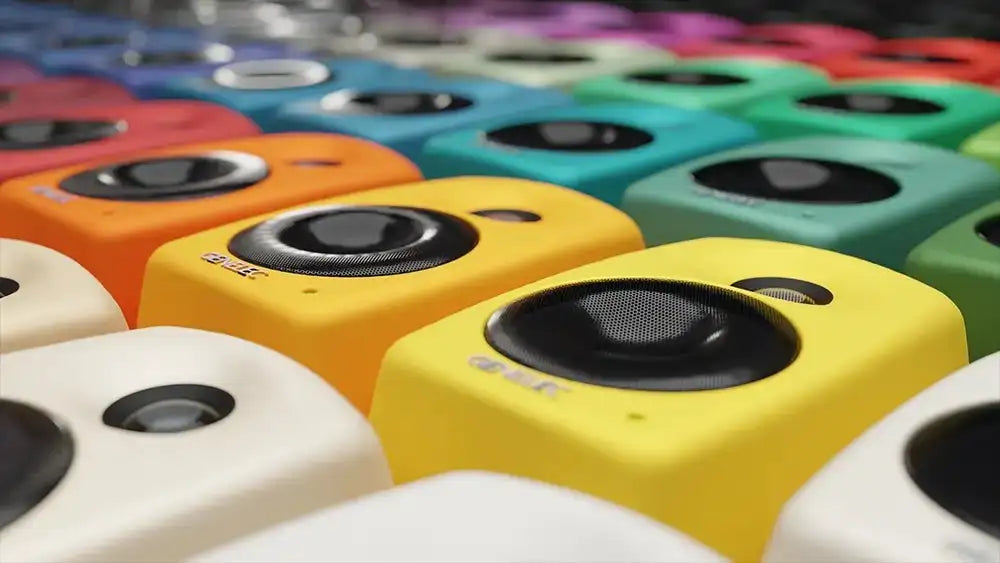 Vibrant yellow cube-shaped bluetooth speakers with black circular drivers and subtle branding.